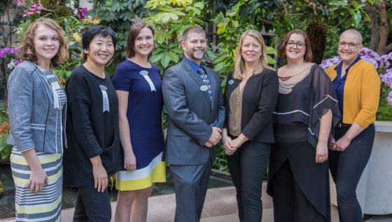 a group of 7 people smiling for a photo 